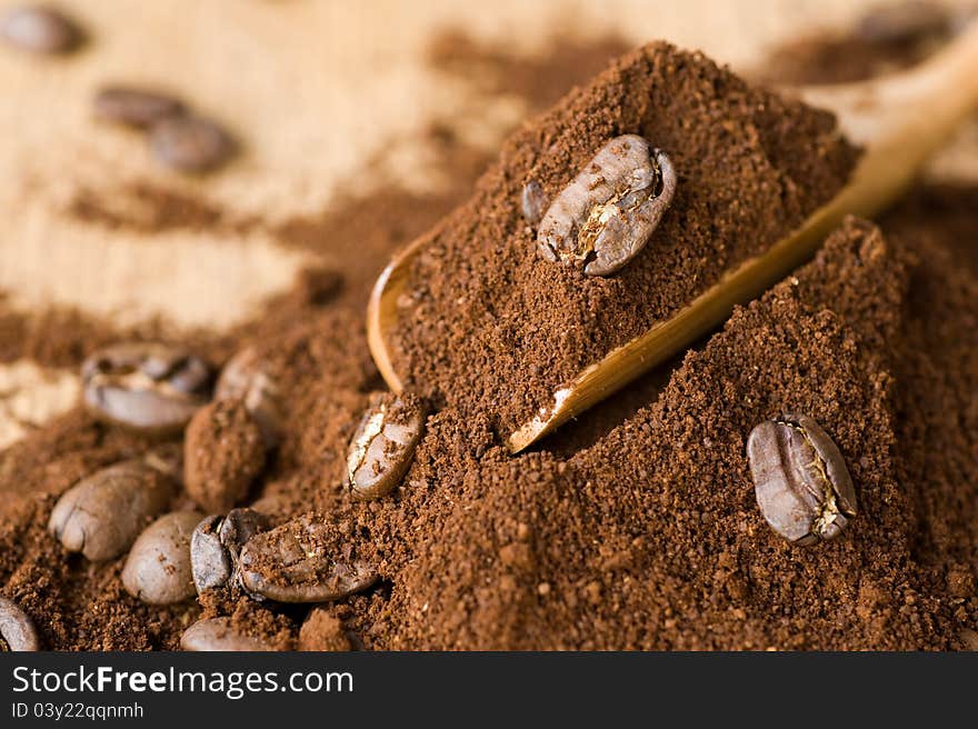 Coffee ground and in the grain a wooden spoon