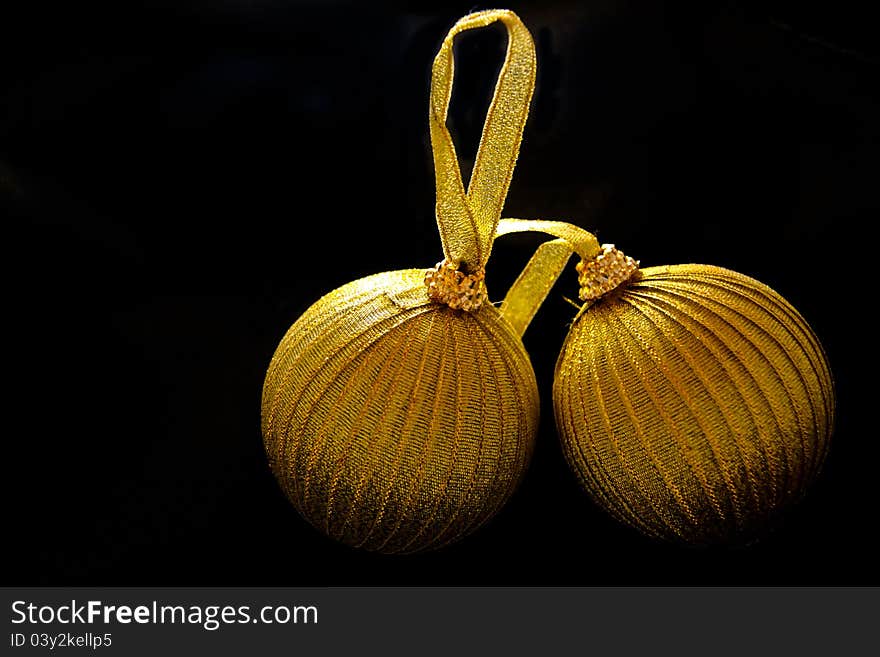 Two golden christmas balls on a black background. Two golden christmas balls on a black background