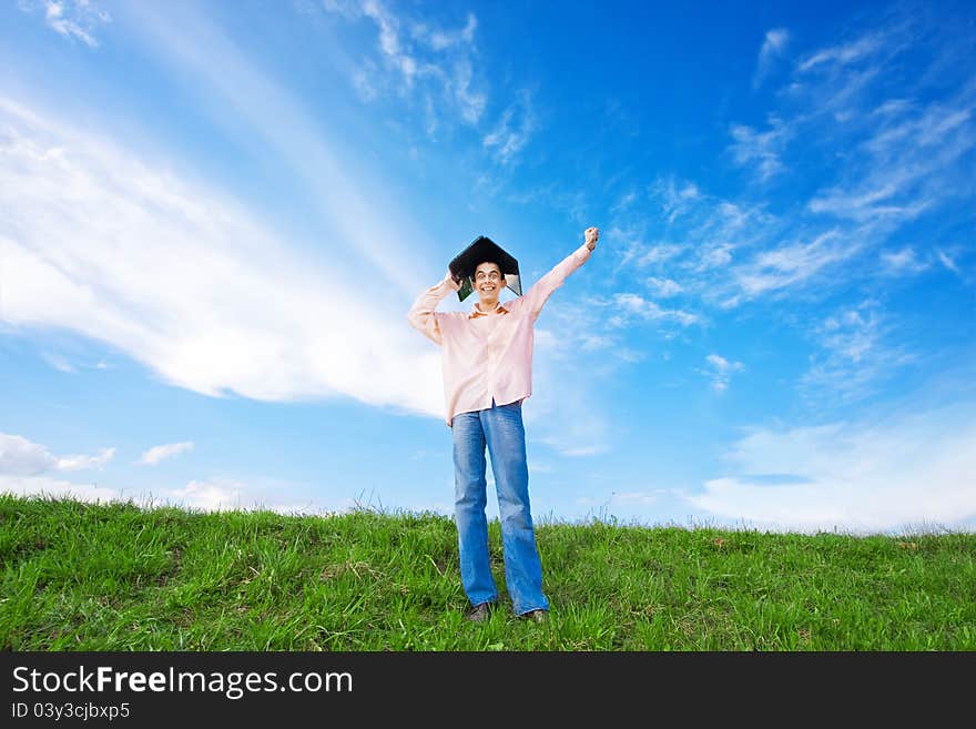 Young man using laptop in the field