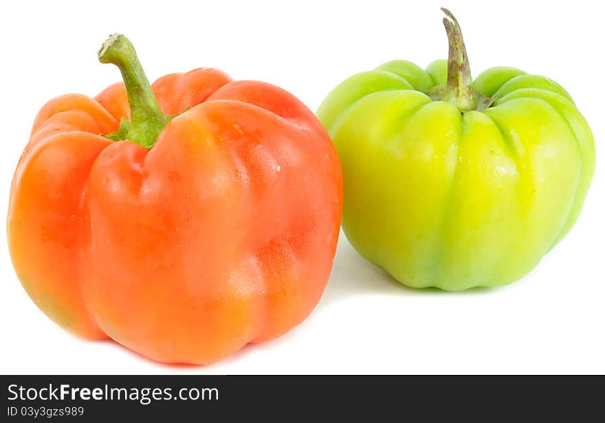 A red and a green bell peppers on a white background. A red and a green bell peppers on a white background