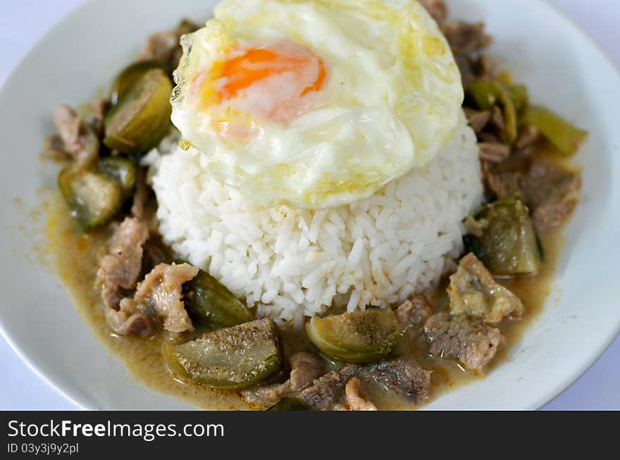 Steamed rice served with fried eggs and beef in ground peanut-coconut cream curry. Steamed rice served with fried eggs and beef in ground peanut-coconut cream curry