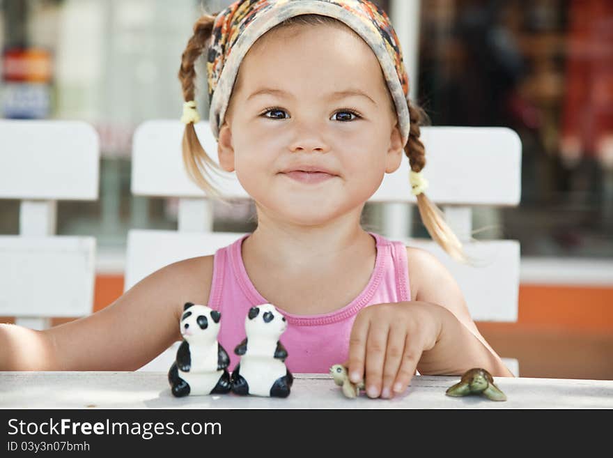 A girl playing with toy pandas at the table