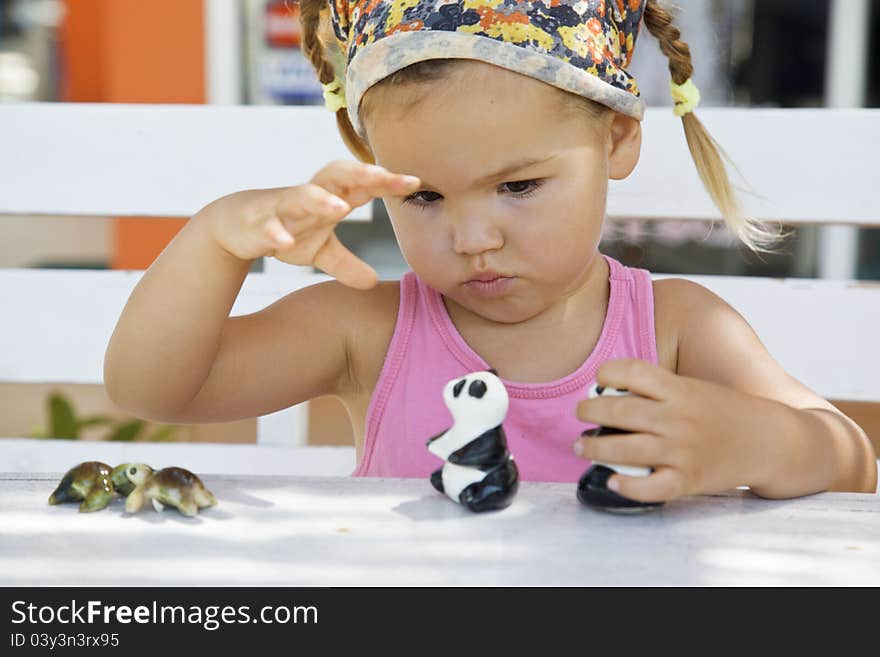 A girl playing with toy pandas at the table