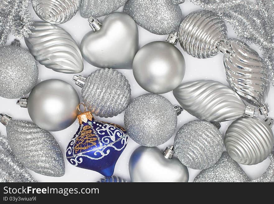 Many silver baubles and one blue on white background. Many silver baubles and one blue on white background