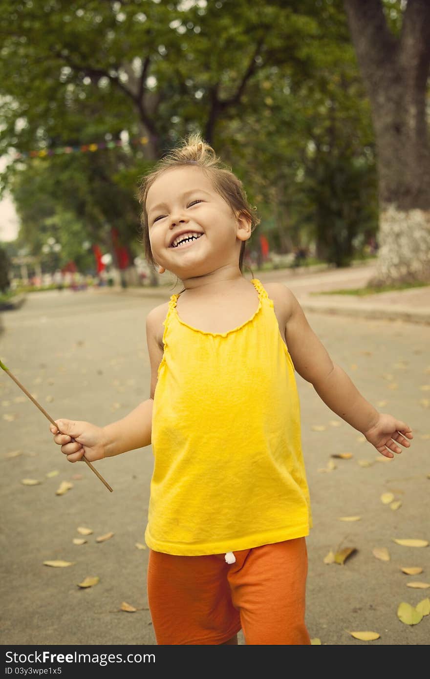 A happy child walking in a park in bright clothes