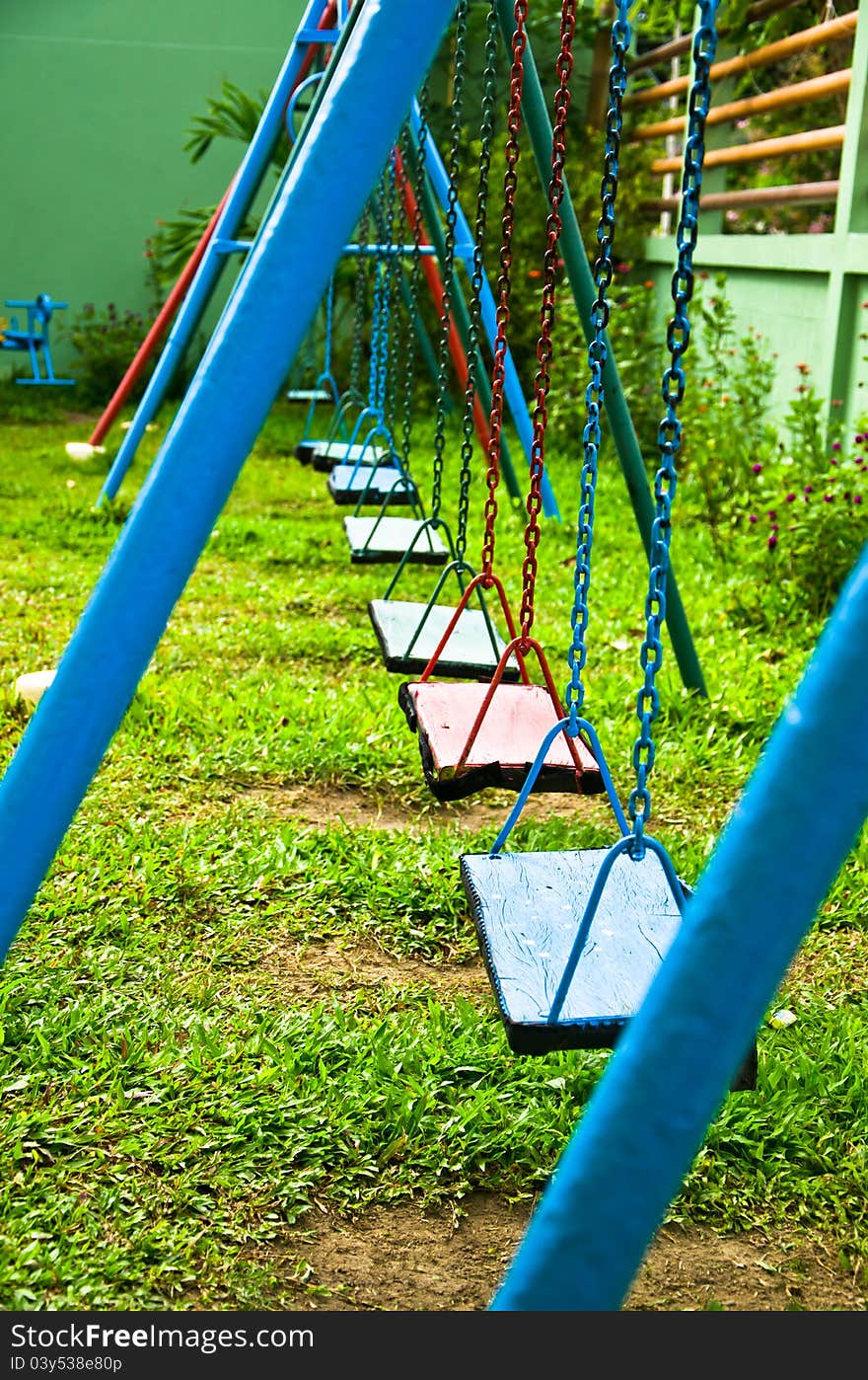 Blue and red swings hanging in the park