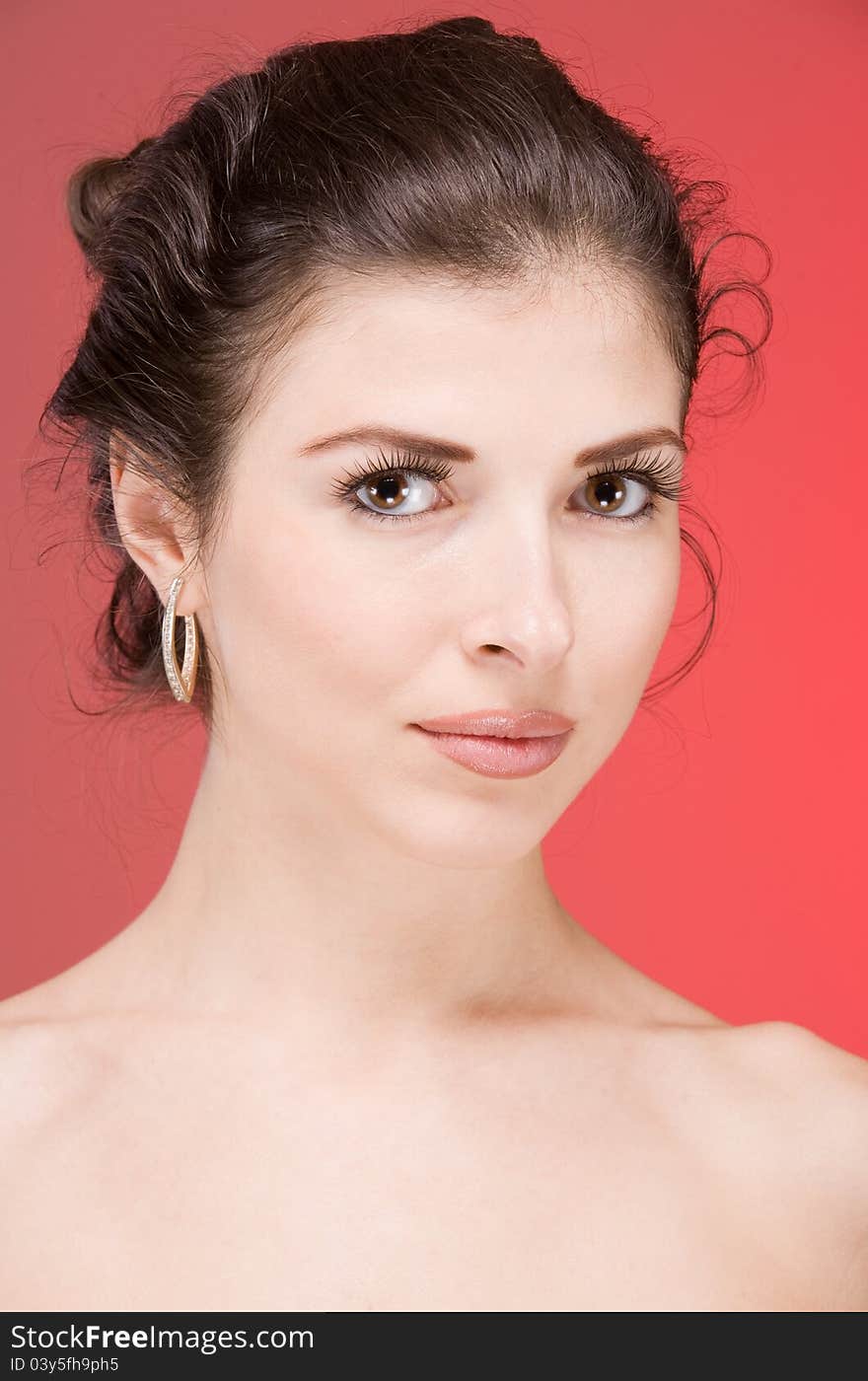 Portrait of the beautiful brunette on a red background. Portrait of the beautiful brunette on a red background