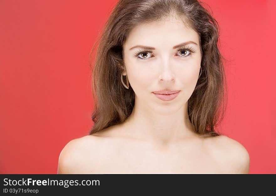 The beautiful dark-haired girl on a red background. The beautiful dark-haired girl on a red background