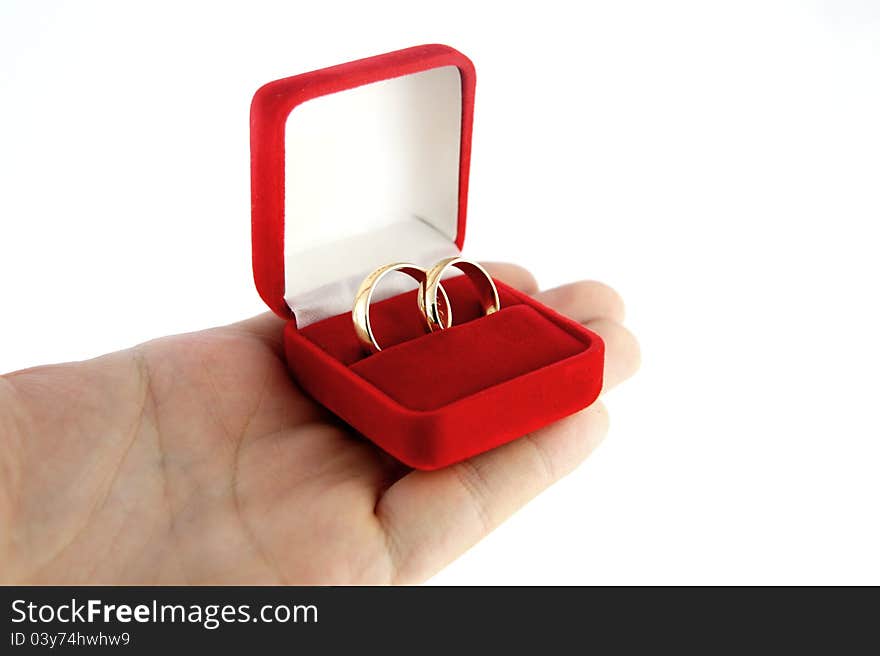 Hand holding a box with wedding rings isolated on white background