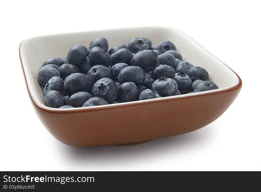 Some wortleberries in the brown ceramic bowl. Some wortleberries in the brown ceramic bowl