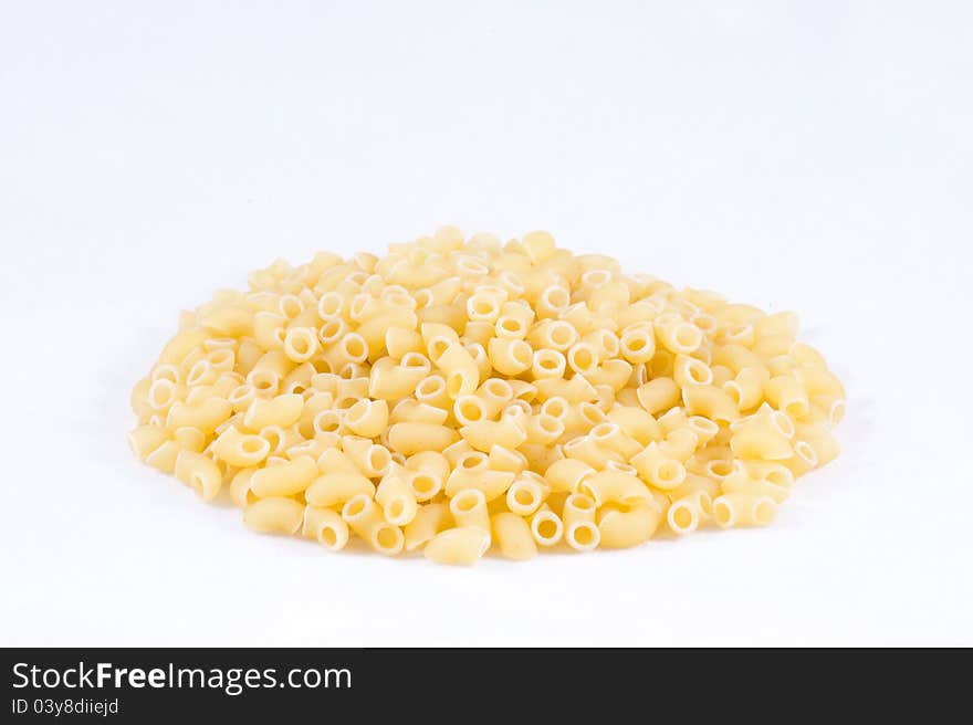 Uncooked small pasta horns with white background