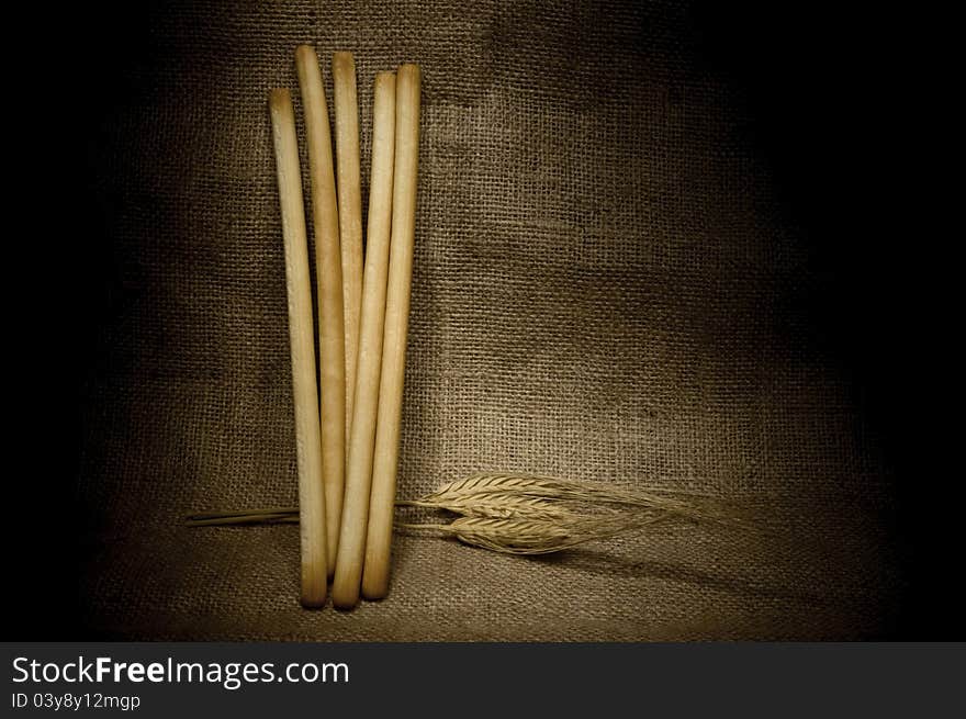 Still life with bread sticks and wheat ears