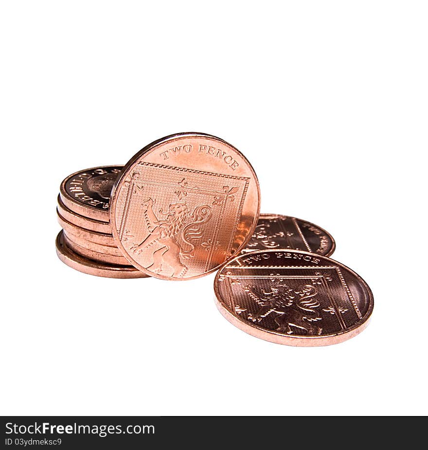 Stacked and flat two pence coins. Isolated on a white background. Focus on upright coin, shallow depth of field.