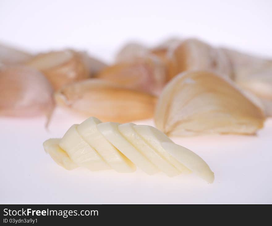 Sliced raw garlic in white background