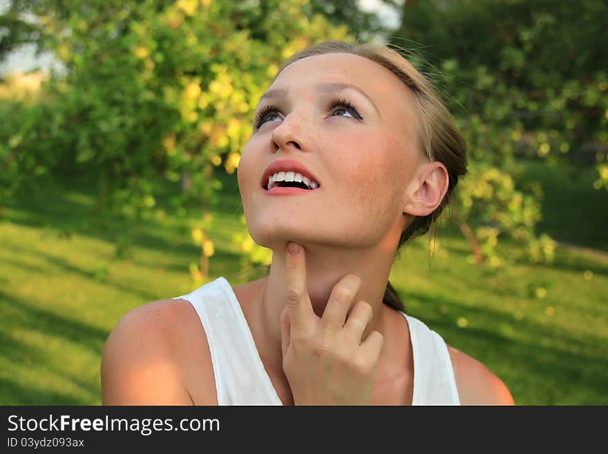 Beautiful young woman in the garden looking up. Beautiful young woman in the garden looking up