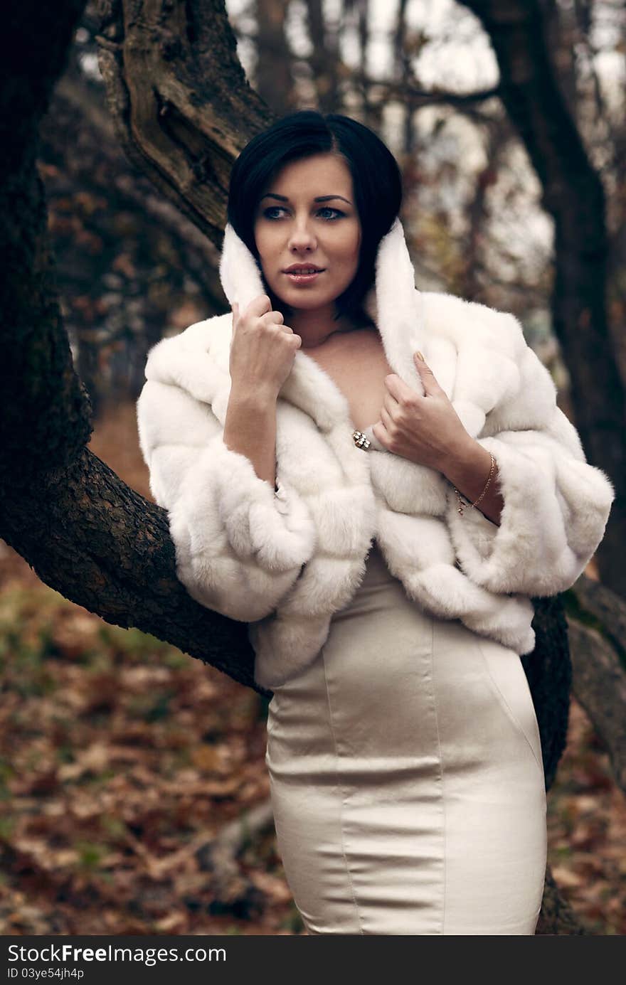 Elegant girl with black hair in white coat with high collar. Elegant girl with black hair in white coat with high collar