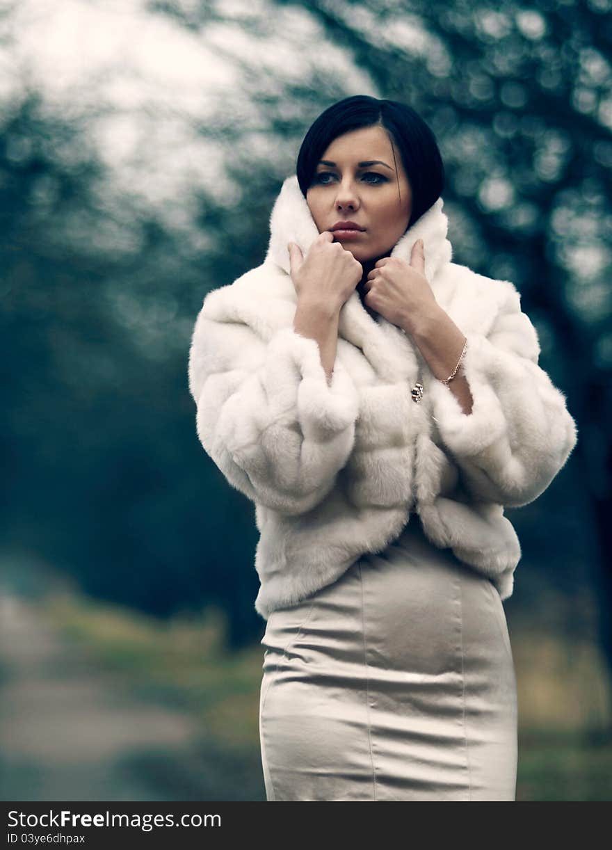 Elegant girl with black hair in white coat with high collar. Elegant girl with black hair in white coat with high collar