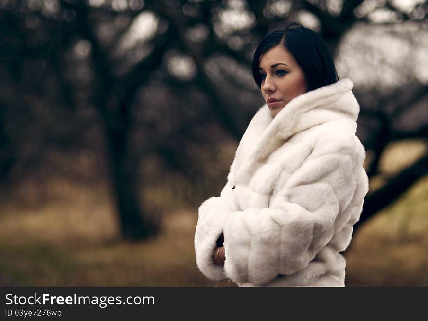 Elegant girl with black hair in white coat with high collar. Elegant girl with black hair in white coat with high collar