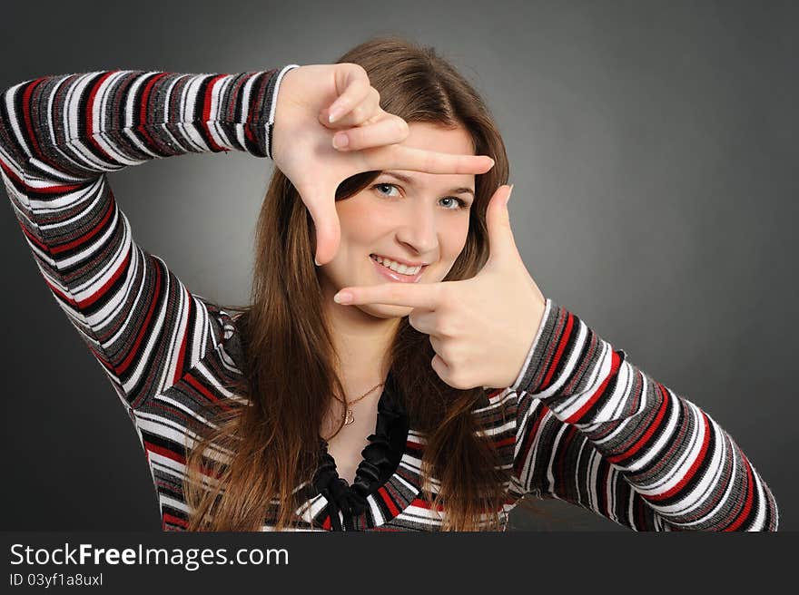 Portrait of a beautiful young woman creating a frame with her hands. Portrait of a beautiful young woman creating a frame with her hands