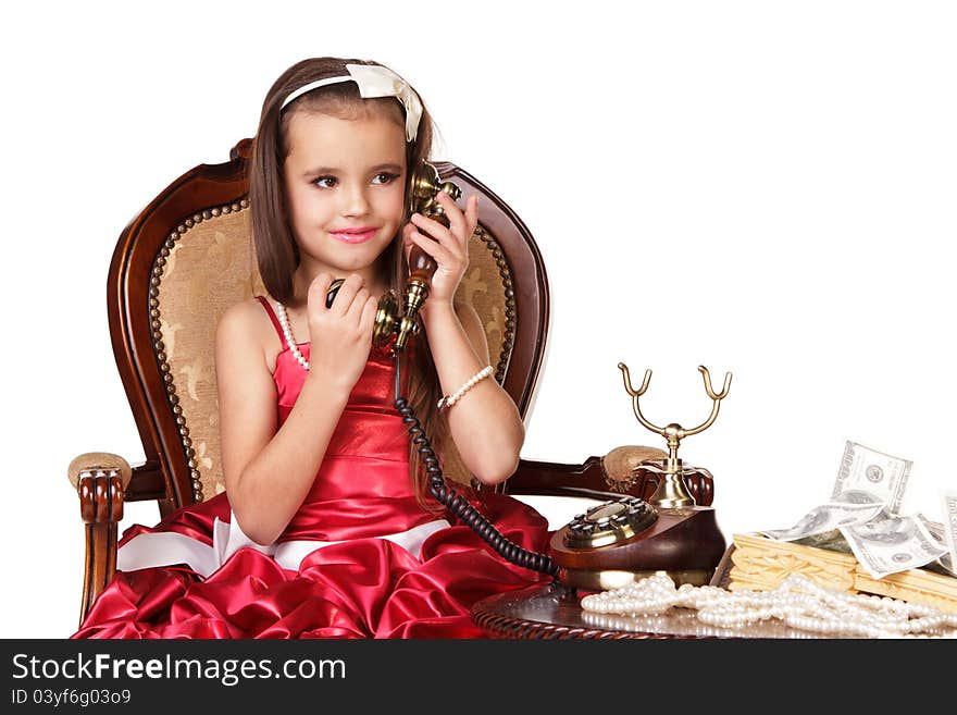 Beautiful little girl in red evening dress speaking on the phone on white background