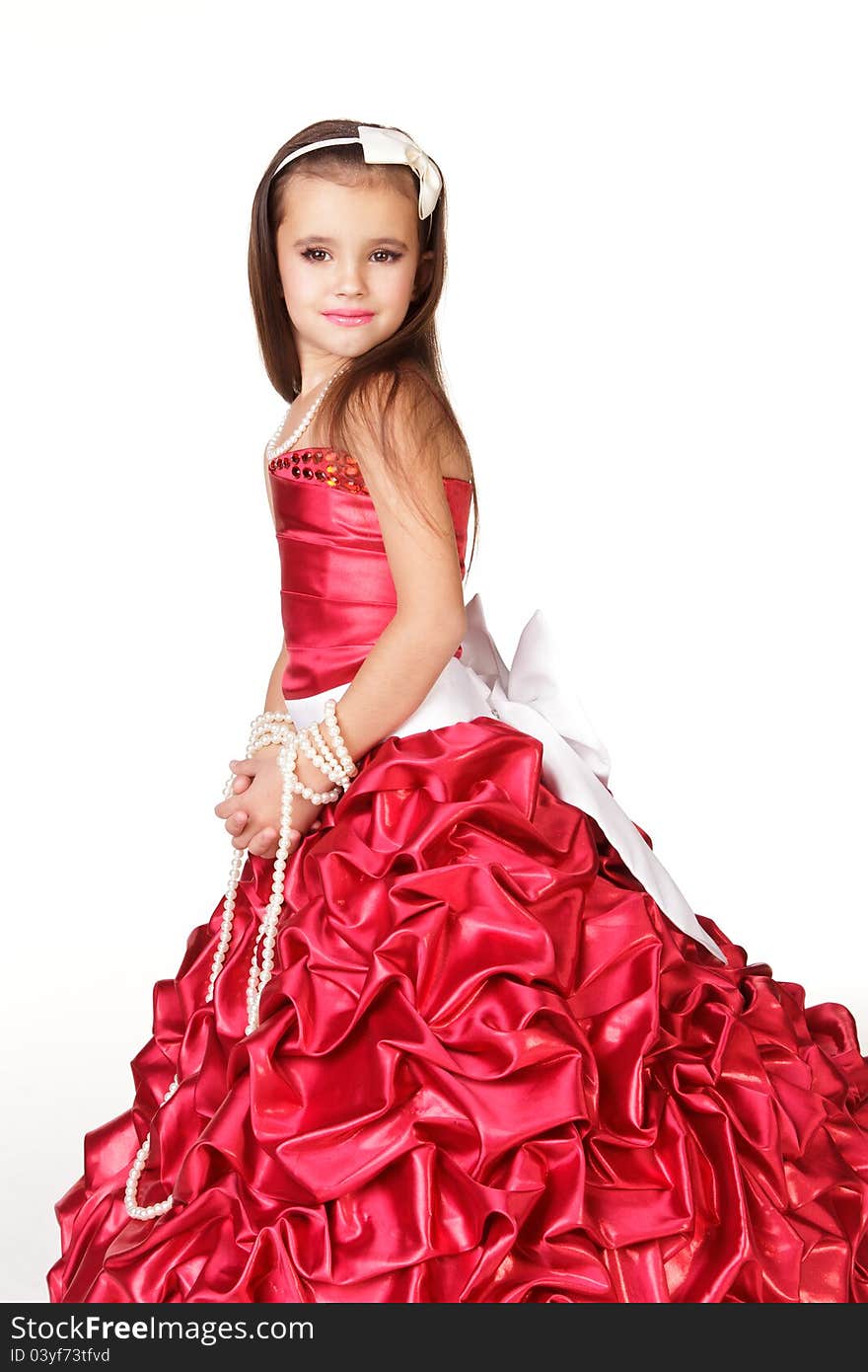 Beautiful little girl in red evening dress on white background