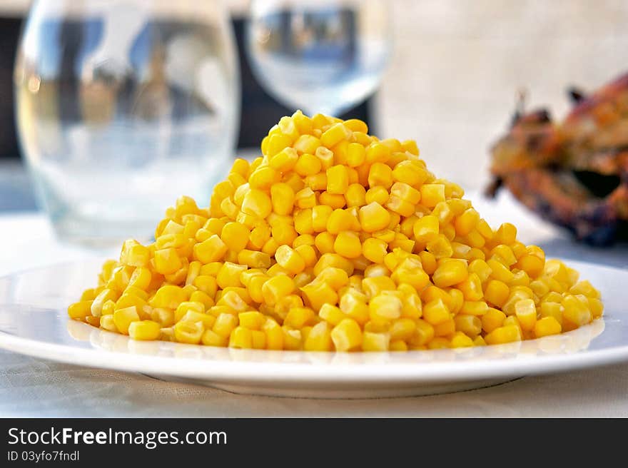 Corn on a plate as part of a dinner table set up