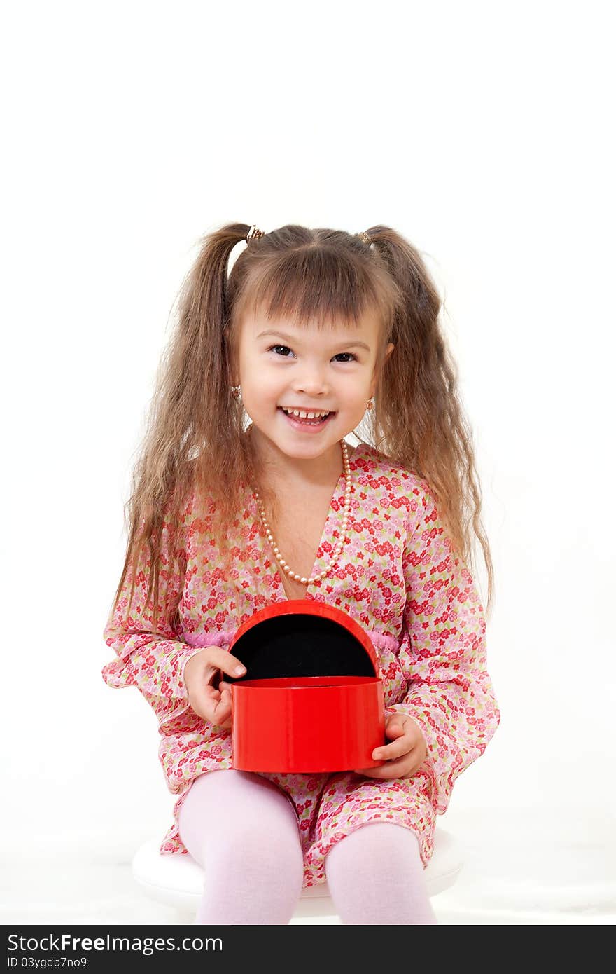 Smiling little girl is happy about her birthday present in red box isolated on white. Smiling little girl is happy about her birthday present in red box isolated on white