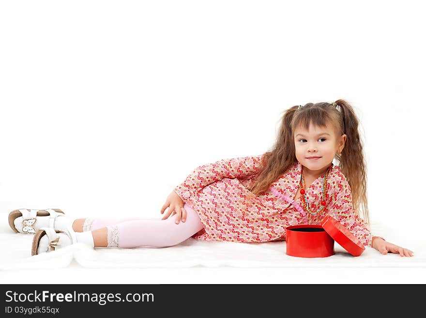 Little girl posing in her new beads present from the box; lying down isolated on white. Little girl posing in her new beads present from the box; lying down isolated on white