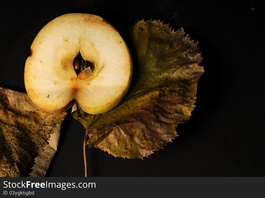 Closeup with sliced apple and leaves studio isolated on black background. Closeup with sliced apple and leaves studio isolated on black background