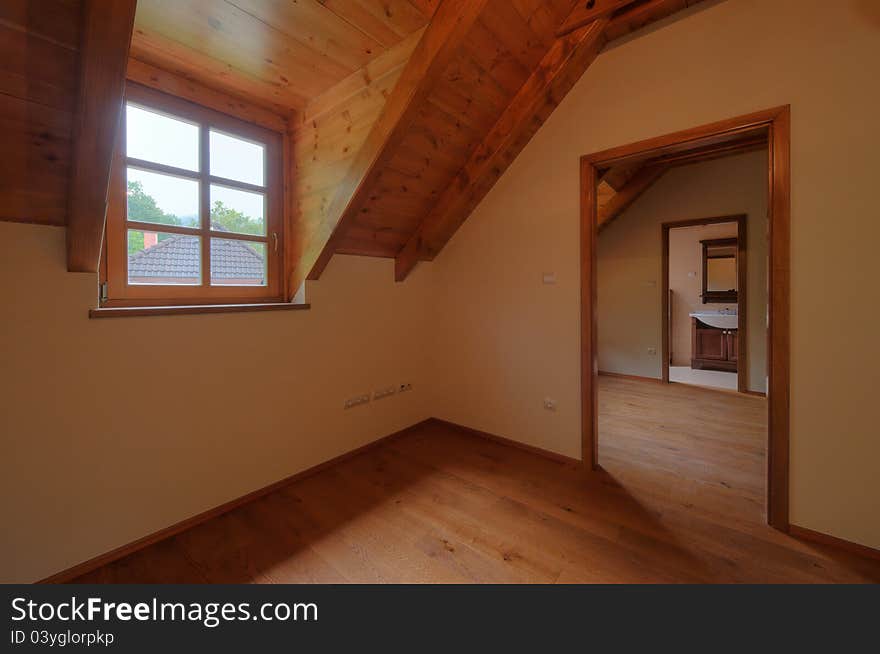 Large, bright, empty room with wooden windows, doors