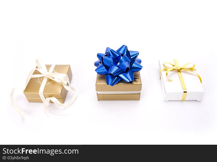 Set of three gold and white gift boxes with blue ribbon. Set of three gold and white gift boxes with blue ribbon.