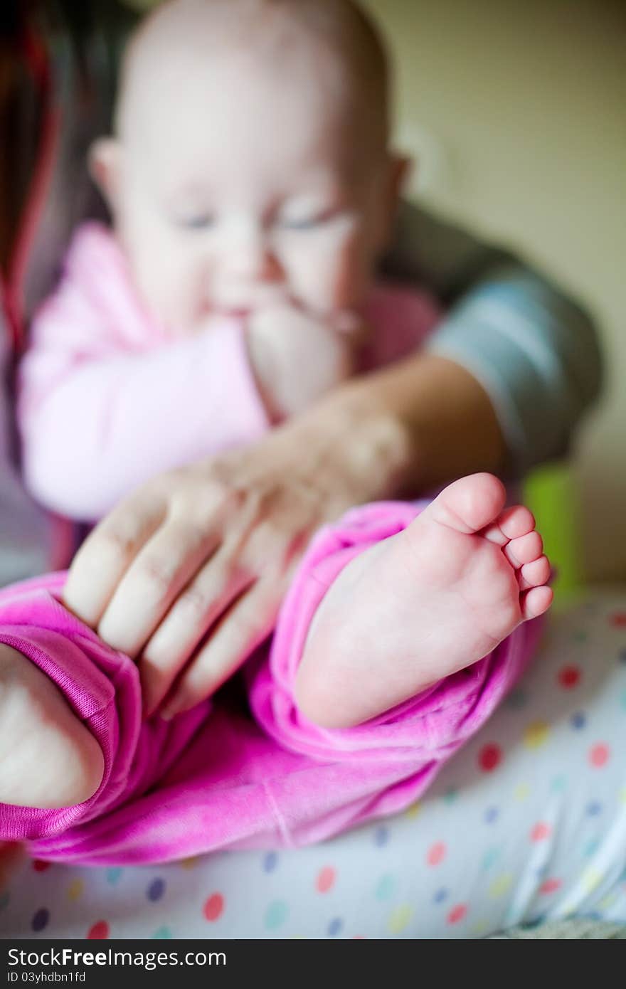 Close-up little feet of a baby girl, the rest of the photo is out of focus. Close-up little feet of a baby girl, the rest of the photo is out of focus