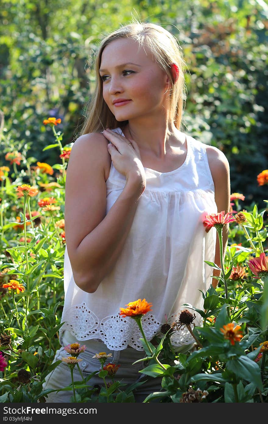 Beautiful young woman among the flowers