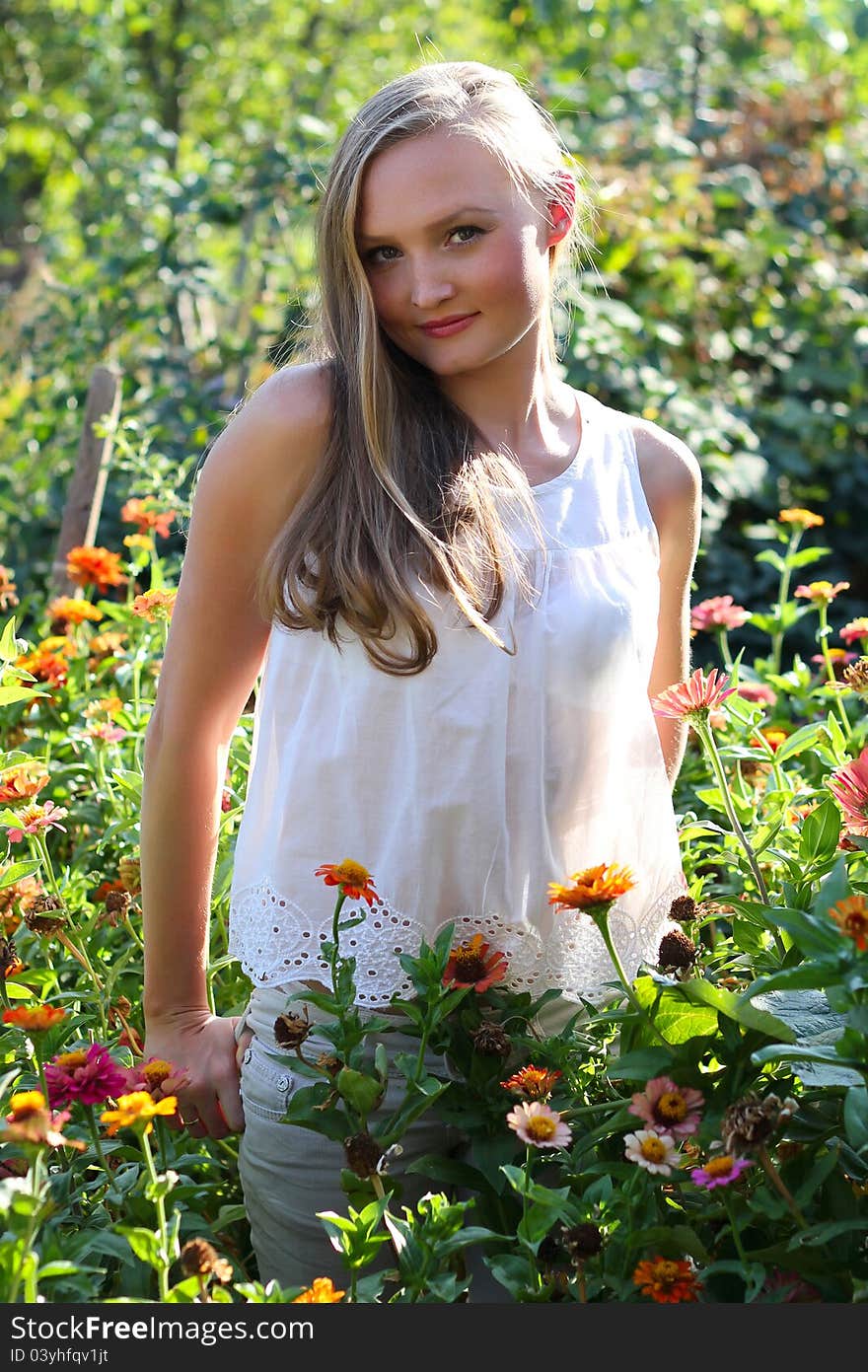 Beautiful young woman among the flowers