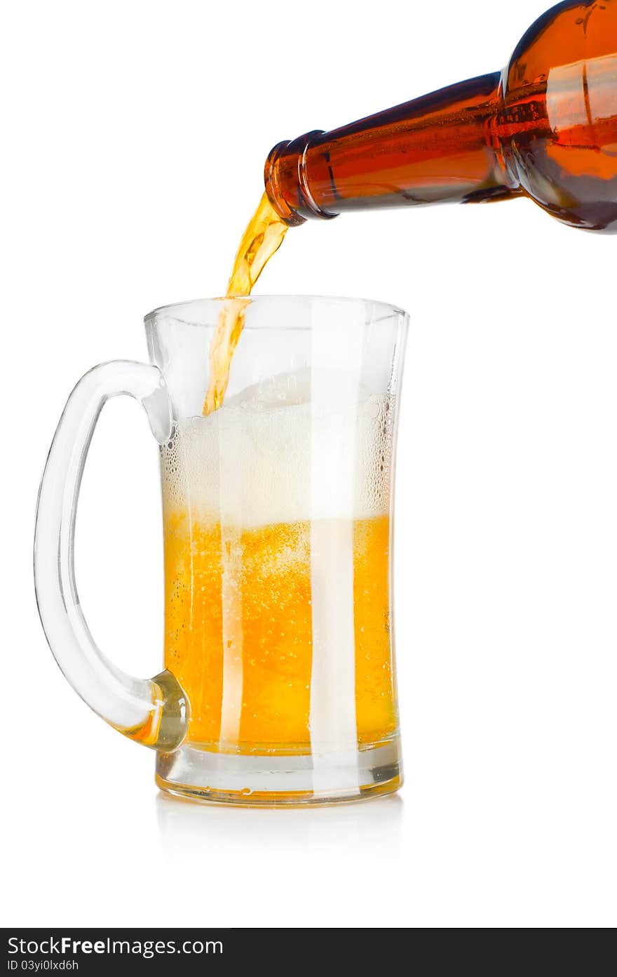 Beer pouring from glass bottle into a mug over white background. Beer pouring from glass bottle into a mug over white background