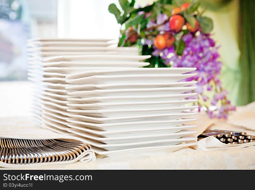 Stacks of white plates for a buffet.