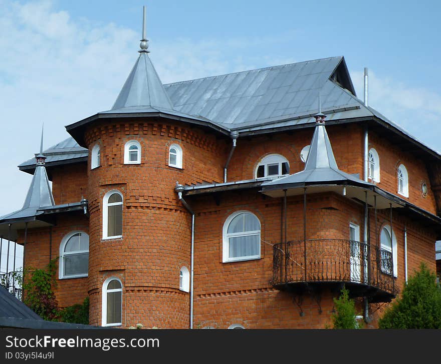 Cottage from red brick on background blue sky