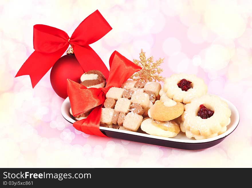 Luxurious festive christmas biscuits with red christmas ball and ribbon. Festive snack background. Luxurious festive christmas biscuits with red christmas ball and ribbon. Festive snack background.