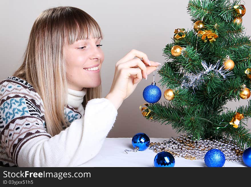 Young woman decorates a Christmas tree. Young woman decorates a Christmas tree