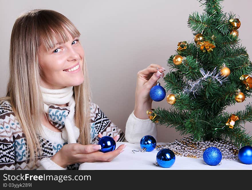 Young woman decorates a Christmas tree. Young woman decorates a Christmas tree