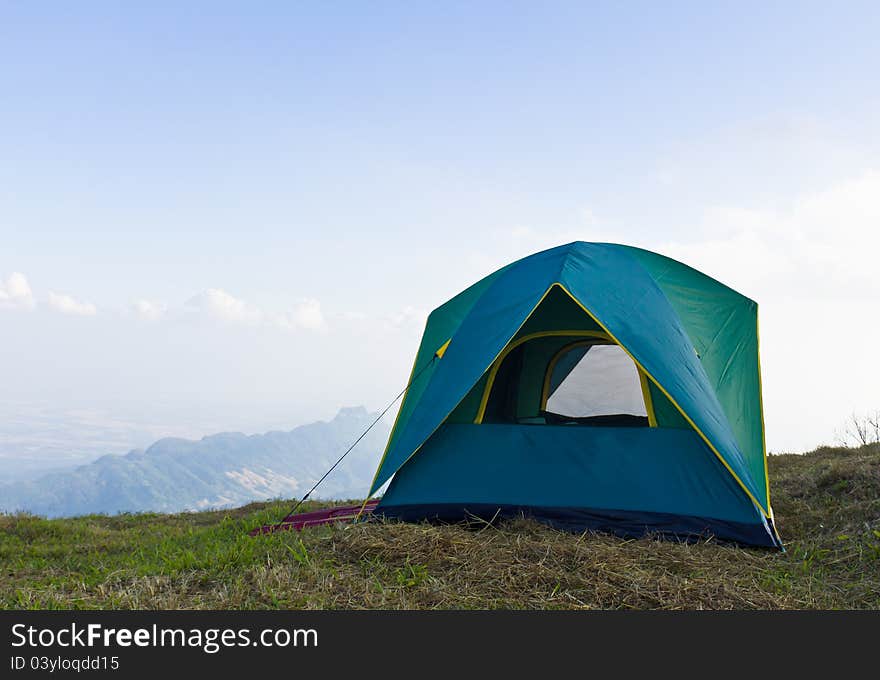 Tent on a grass under white clouds and blue sky