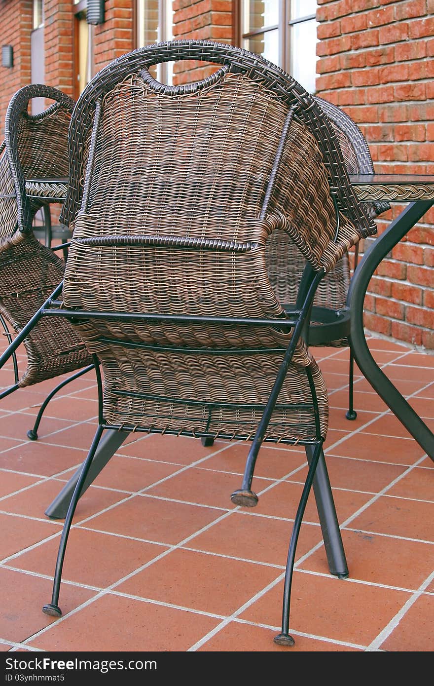 Folded wicker chairs and a table in a street cafe. Folded wicker chairs and a table in a street cafe