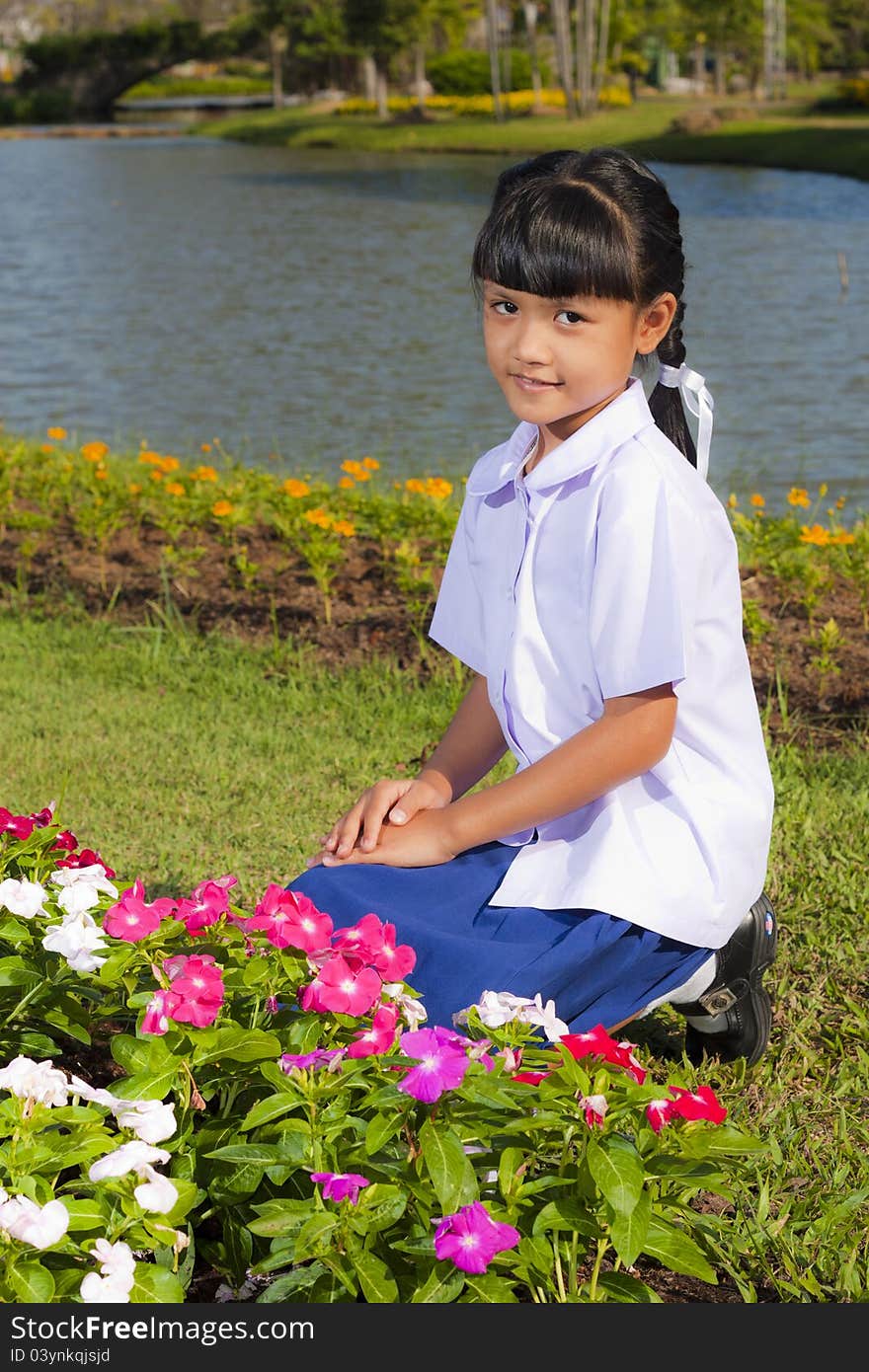 Little asian girl in student uniform smile on flowers background. Little asian girl in student uniform smile on flowers background