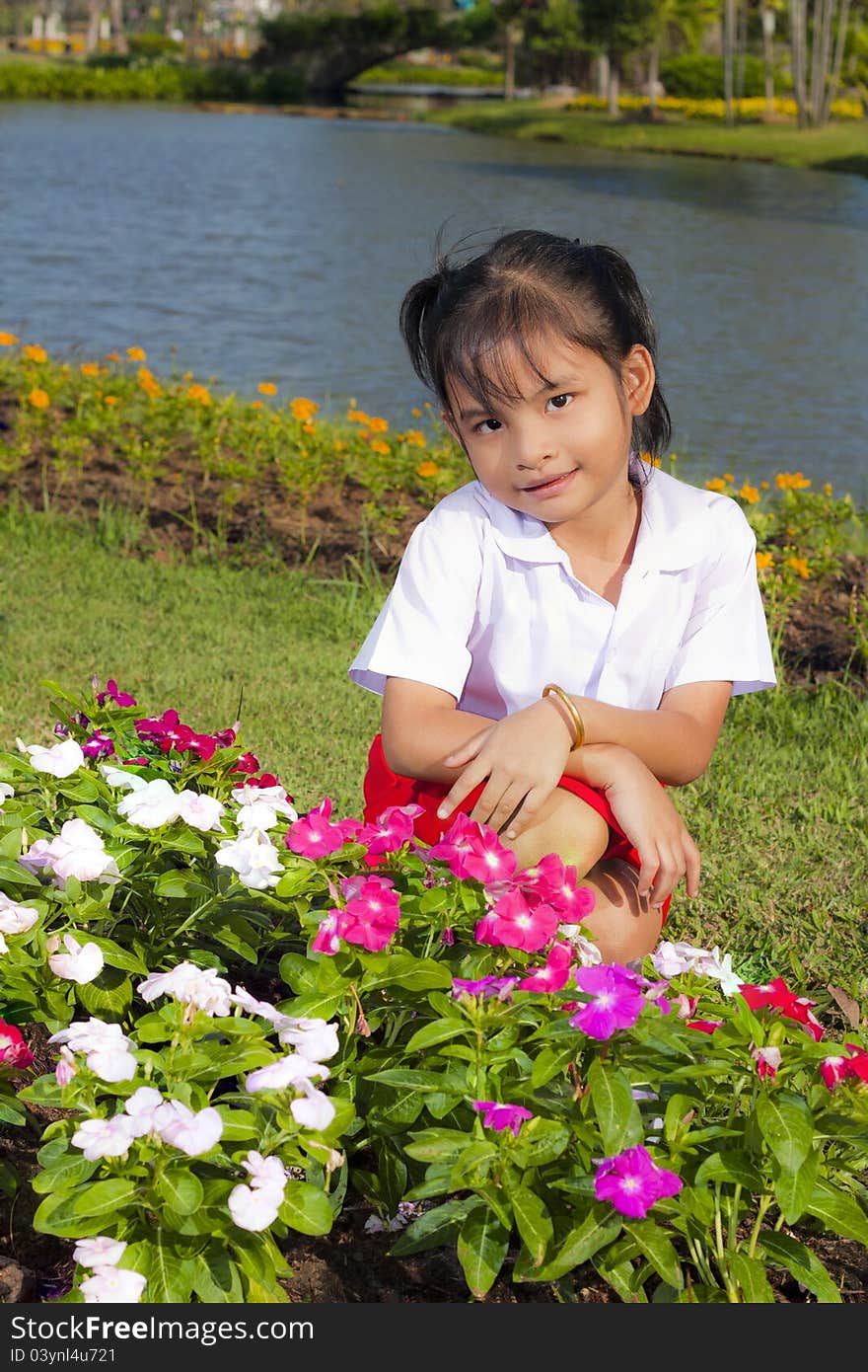 Little asian girl in student uniform smile on flowers background. Little asian girl in student uniform smile on flowers background