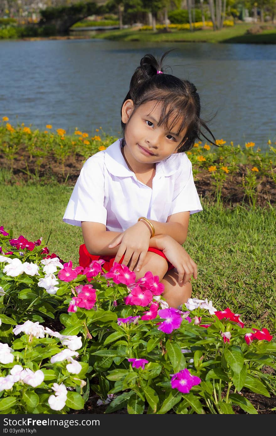 Little asian girl in student uniform smile on flowers background. Little asian girl in student uniform smile on flowers background