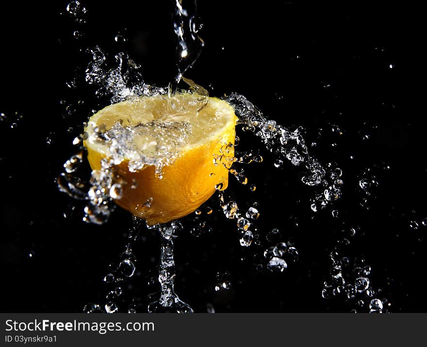 Fresh water splash and lemon isolated on black. Fresh water splash and lemon isolated on black.