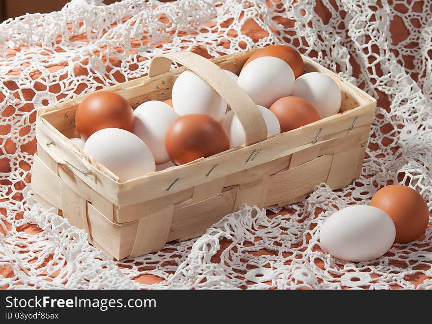 Eggs, yellow and white in a basket on a white lacy napkin. Eggs, yellow and white in a basket on a white lacy napkin