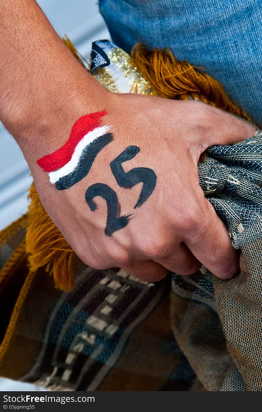 An young person keep on his hand a carpet for islamic pray, on his hand also there is the date of the egyptian revolution . the revolution start from the young people . An young person keep on his hand a carpet for islamic pray, on his hand also there is the date of the egyptian revolution . the revolution start from the young people .