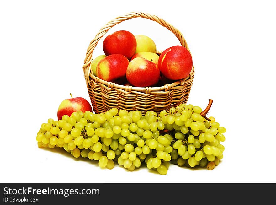 Apples in a basket and grapes in the foreground