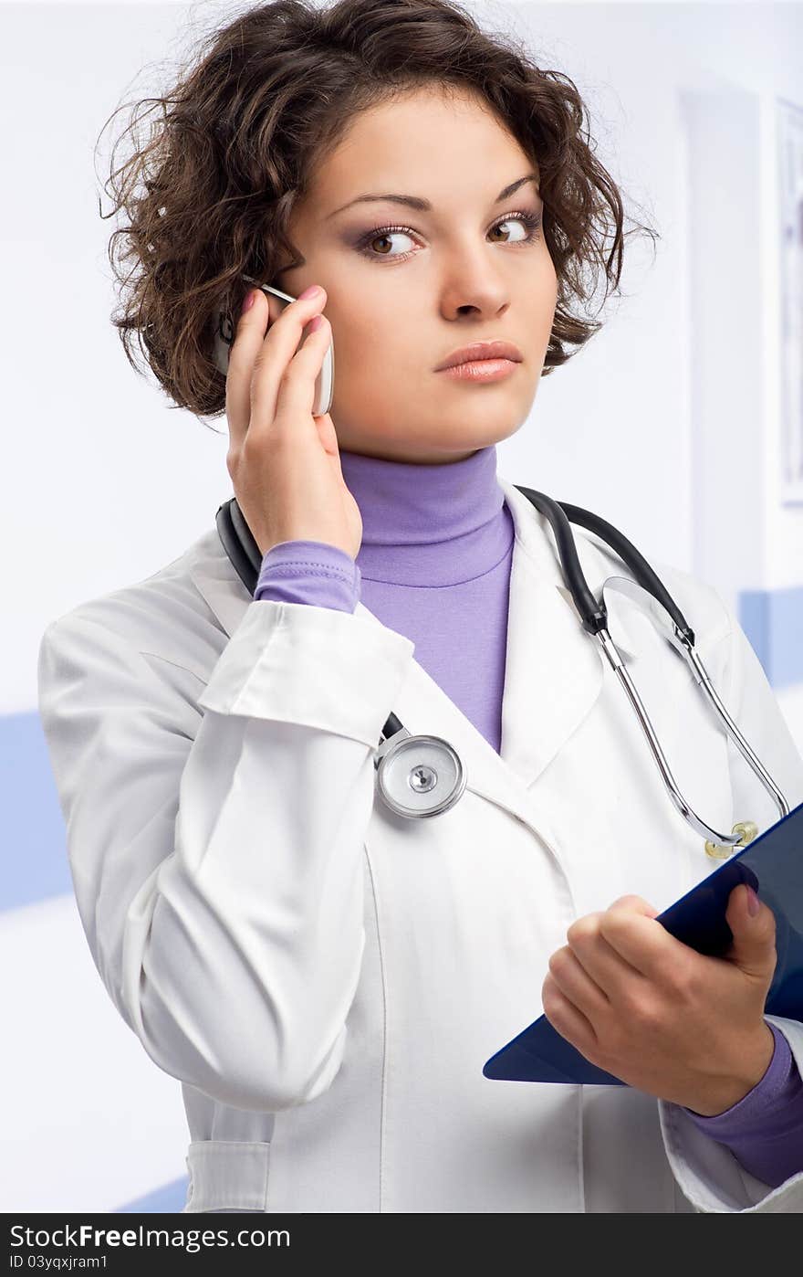 Young doctor in medical gown and a stethoscope and file folder in an hospital. Young doctor in medical gown and a stethoscope and file folder in an hospital